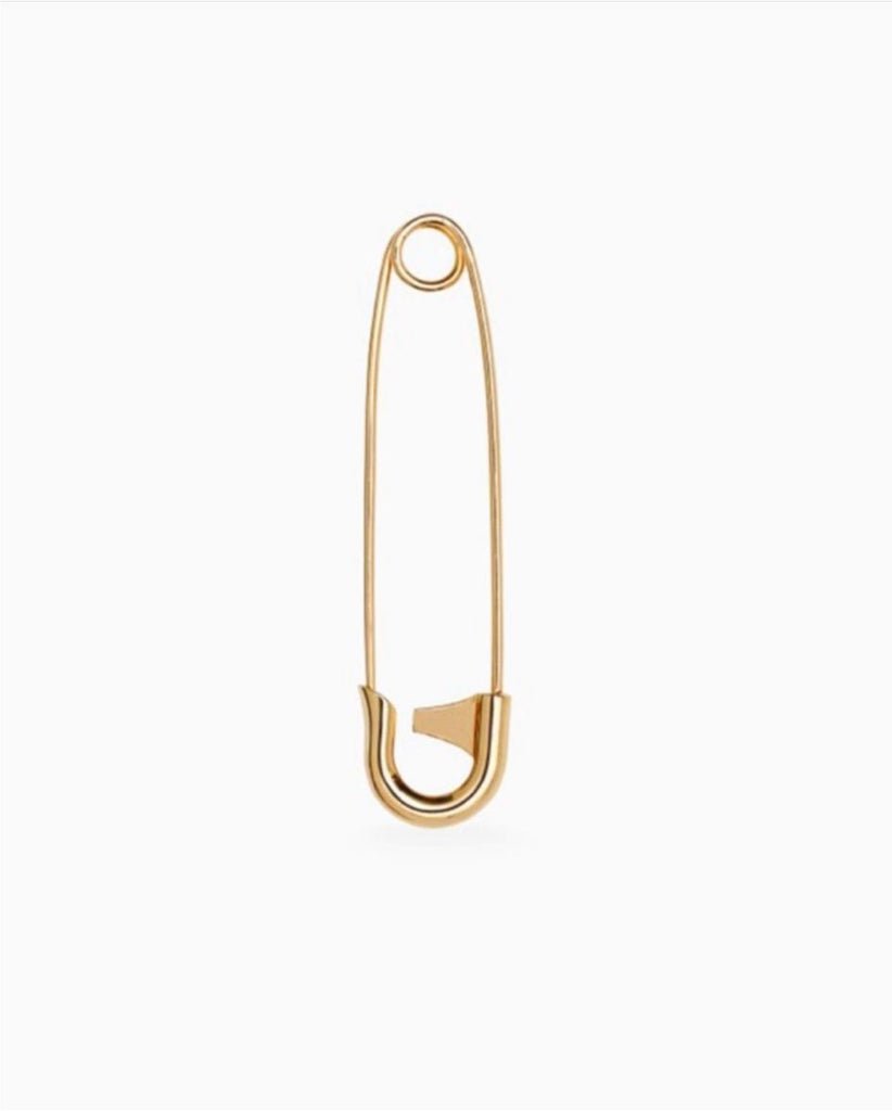 A single safety pin pendant made of 18 karat yellow gold, displayed against a white background.